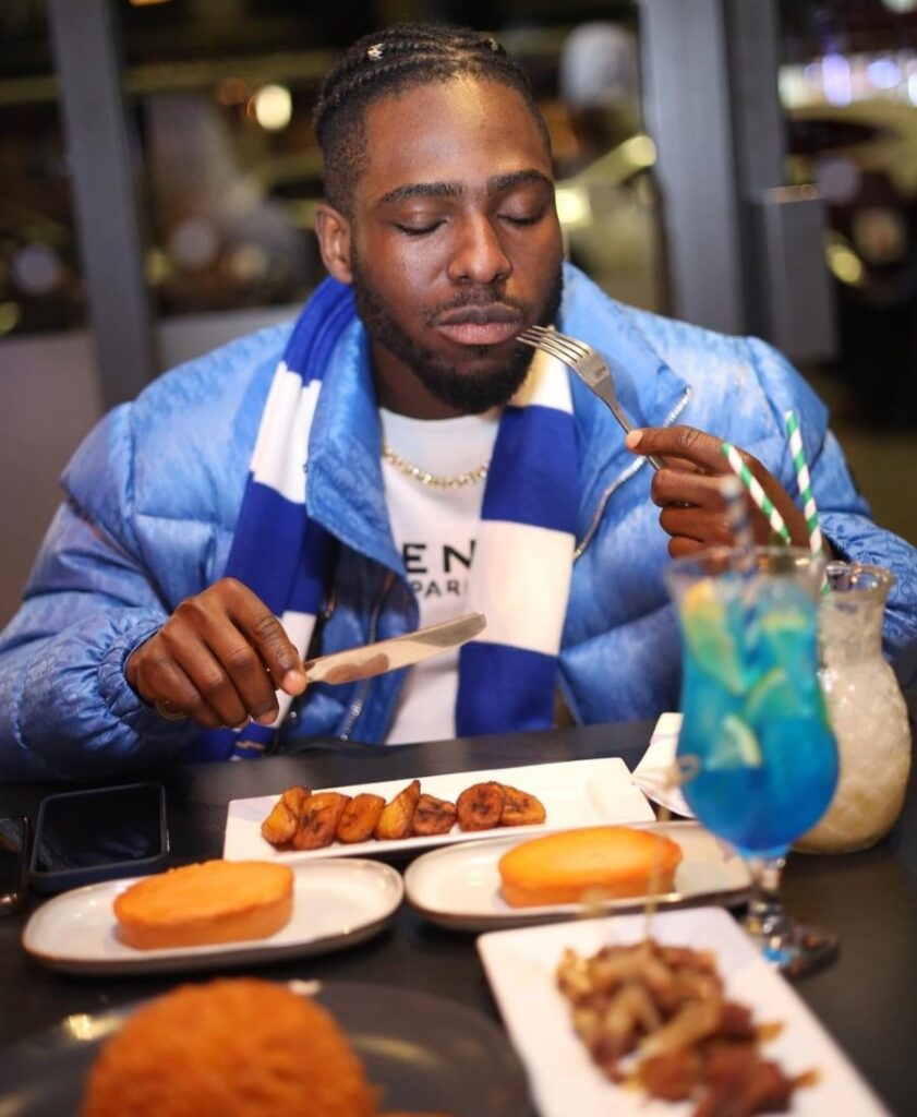 A young man having a savoury meal at demi's restaurant, closing his eyes and enjoying the rich taste of the food.